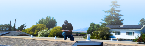 Roofing professional inspecting a roof with text on the image reading "What a Roof Inspection Costs in the Bay Area and When to Book One Before the Rains"