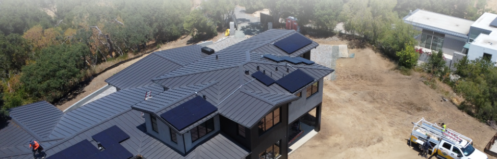 Aerial view of a home under construction with a team installing solar panels. Text on the image reads "Bring Your Solar Contractor in Before Plans Area Finalized"
